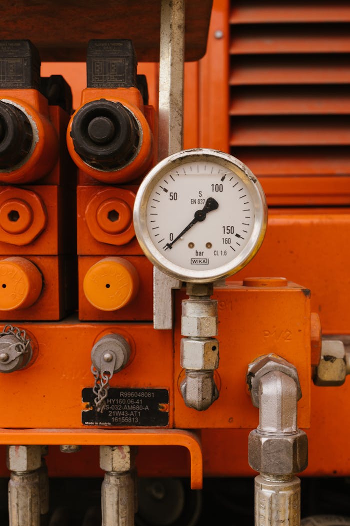 contact-img Detailed view of a pressure gauge on orange industrial machinery, showcasing engineering equipment.